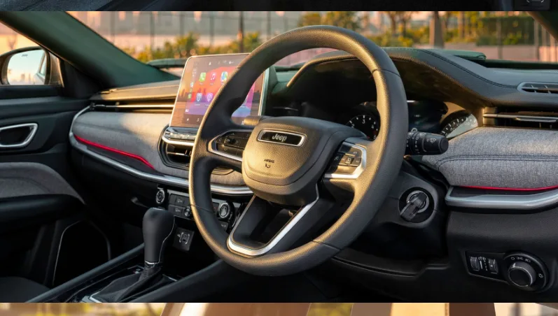 The Compass Sport 9AT features a dark cabin theme with grey fabric inserts on the dashboard and door pads.